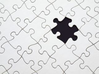 Puzzle presque terminé sur une table, avec un espace vide là où manque une pièce